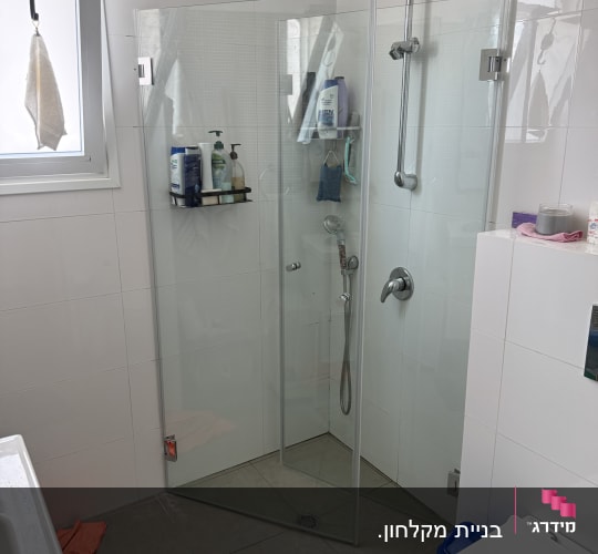 חדר אמבטיה עם מקלחון זכוכית וכלי רחצה